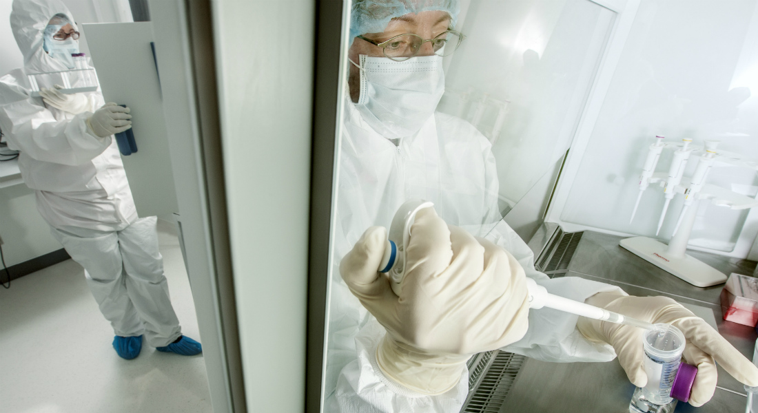 Two scientists wearing protective clothing working in a cleanlab.