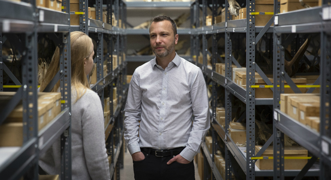 Rasmus Nielsen speaking with another researcher in a storage room.