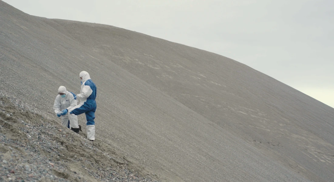 Researchers collecting samples on a hill.