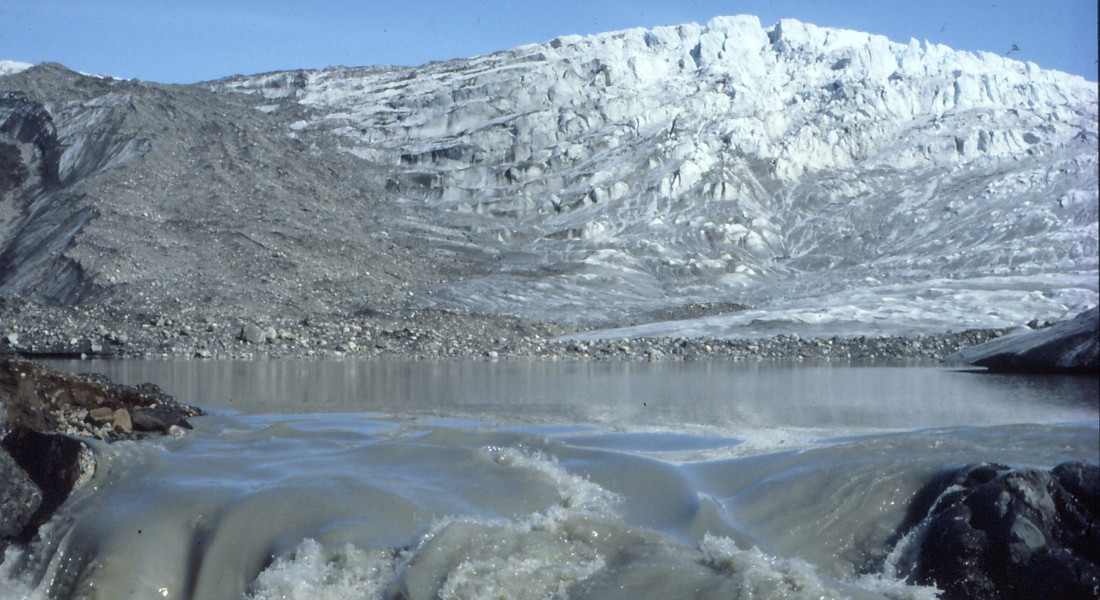 icey mountain in front of soaring waters under blue skies