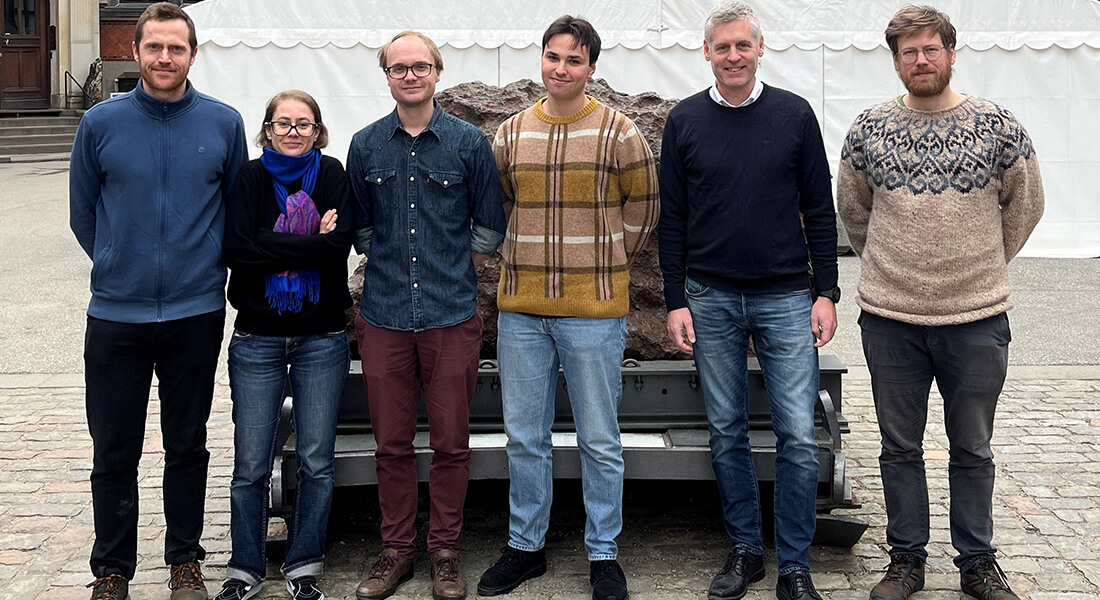 The Hassenkam group standing in front of  the meteor in the Geological Museum's courtyard.